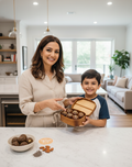 Woman and child in a kitchen with a box of energy balls from brain and body fuel Co.